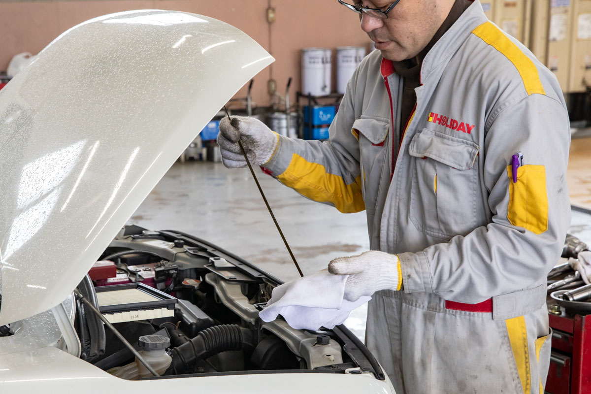 エンジンオイルの点検をする整備士